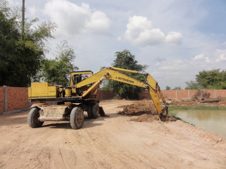 Bagger bearbeitet den Fischteich