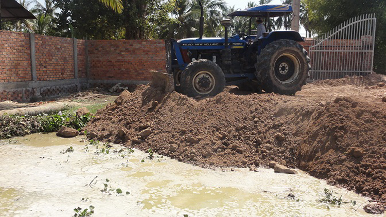 Traktor verteilt das Erdreich auf unserem Grundstück