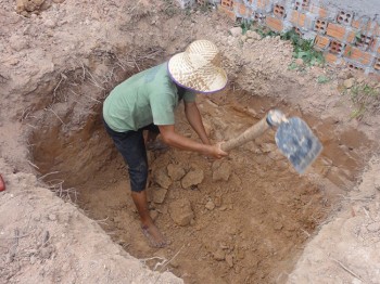 Arbeiter gräbt ein Loch auf unserem Grundstück