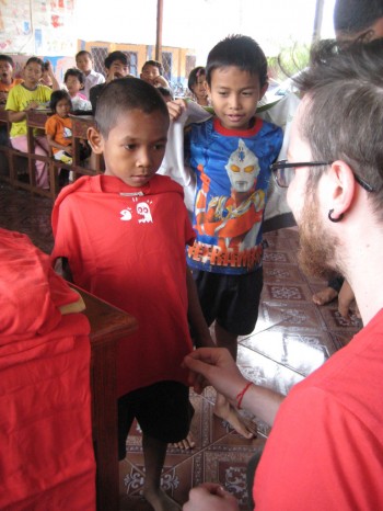 Christoph überreicht den Kindern T-Shirts vom Verein Schräg