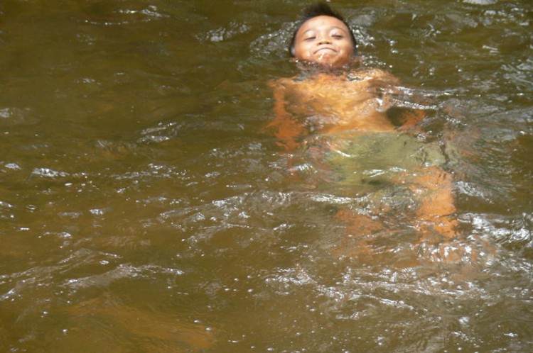 Eines der Kinder schwimmt im Wasser